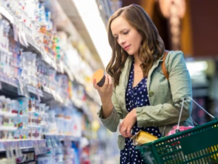 Woman reading food label at a supermarket