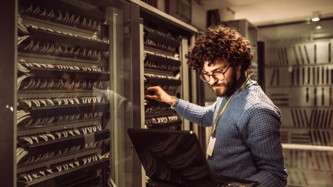 bearded male worker in mainframe room