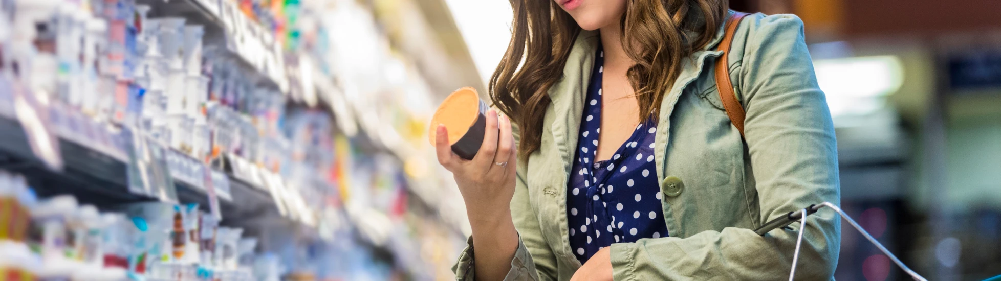 Woman reading food label at a supermarket